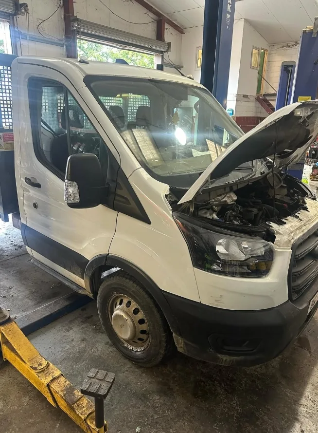Commercial Ford van in the workshop with its bonnet open for repairs