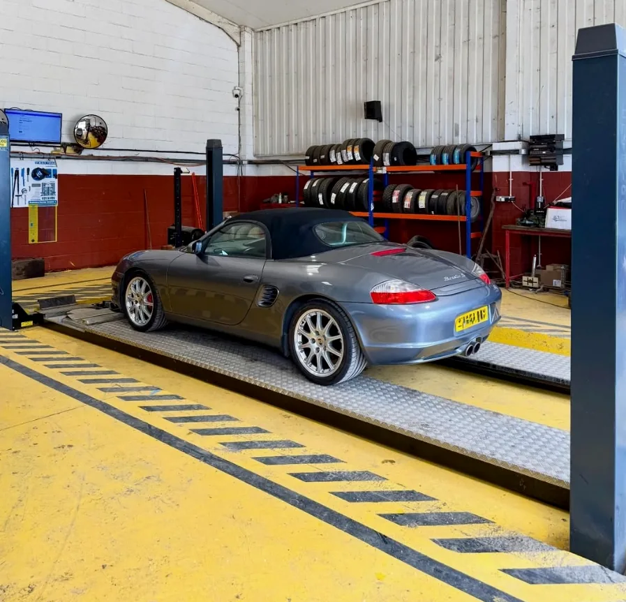 Car in the Top Plant Garage workshop with tyre racks in the background